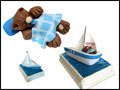 marine theme baby shower cake with a sleeping bear cub and a sail boat