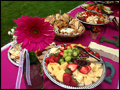 Colorful catered platters table decorated with fresh flowers