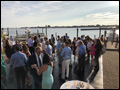 Wedding guests mingling, enjoying good food and conversation on a dance floor at a catered waterfront wedding